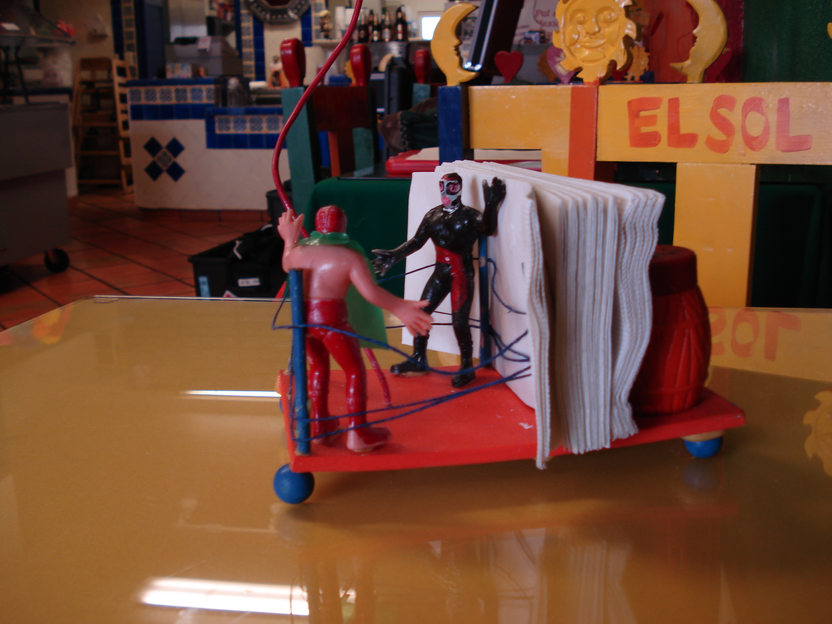 <a href="http://mamatestataqueria.com/">Mamá Testa</a>'s salt and pepper shakers live on little platforms with poseable luchador toys.