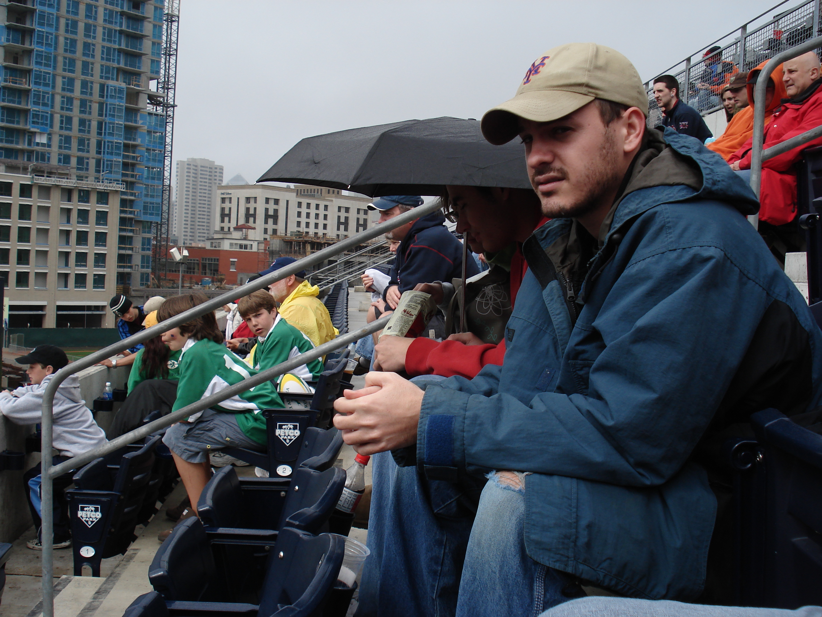 Pensive Lee while Brad & Bethany huddle under the umbrella