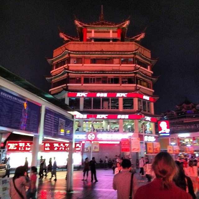 A six-storey Kentucky Fried Chicken with traditional Chinese architectural features stands above a busy city street.