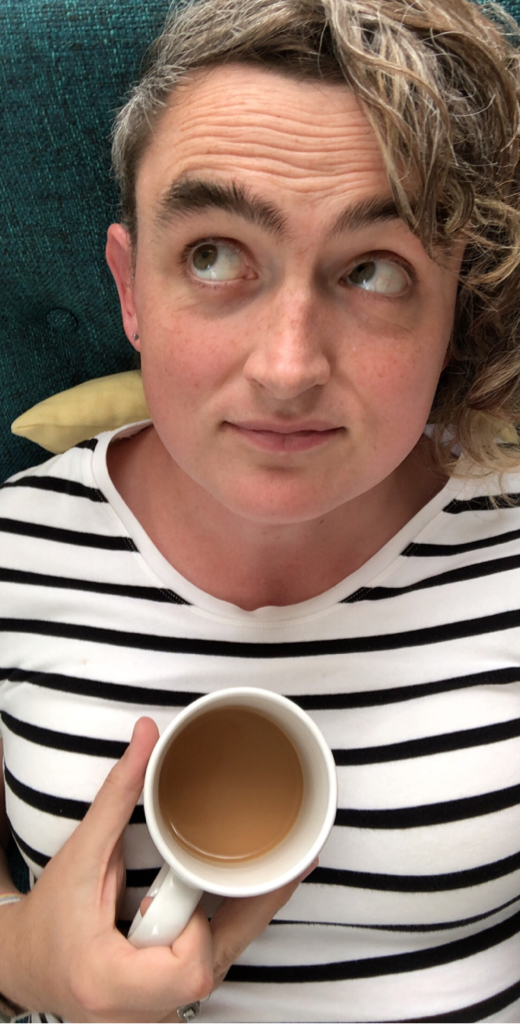a photo of me, lounging on a couch with a cup of tea.