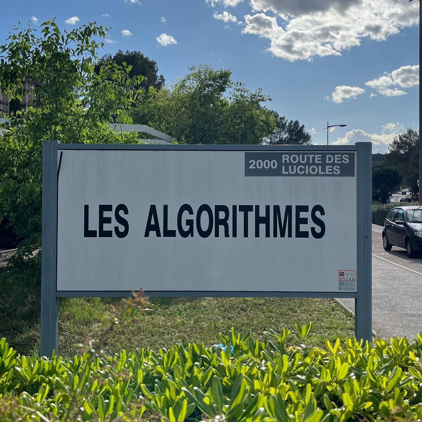 A large white road sign reads “Les Algorithmes”.
