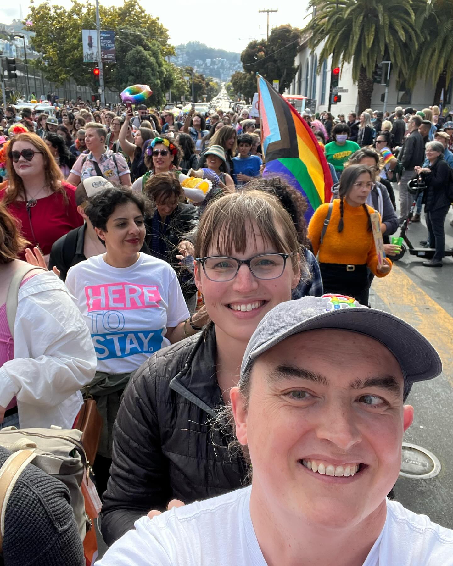 Eryn and I march down the street in a large crowd.
A few rows behind us someone waves a pride flag.