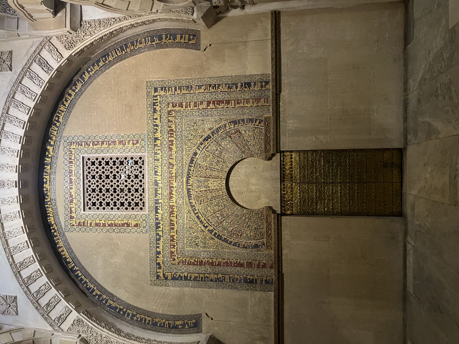 Arabic writing around an arch near the mihrab.