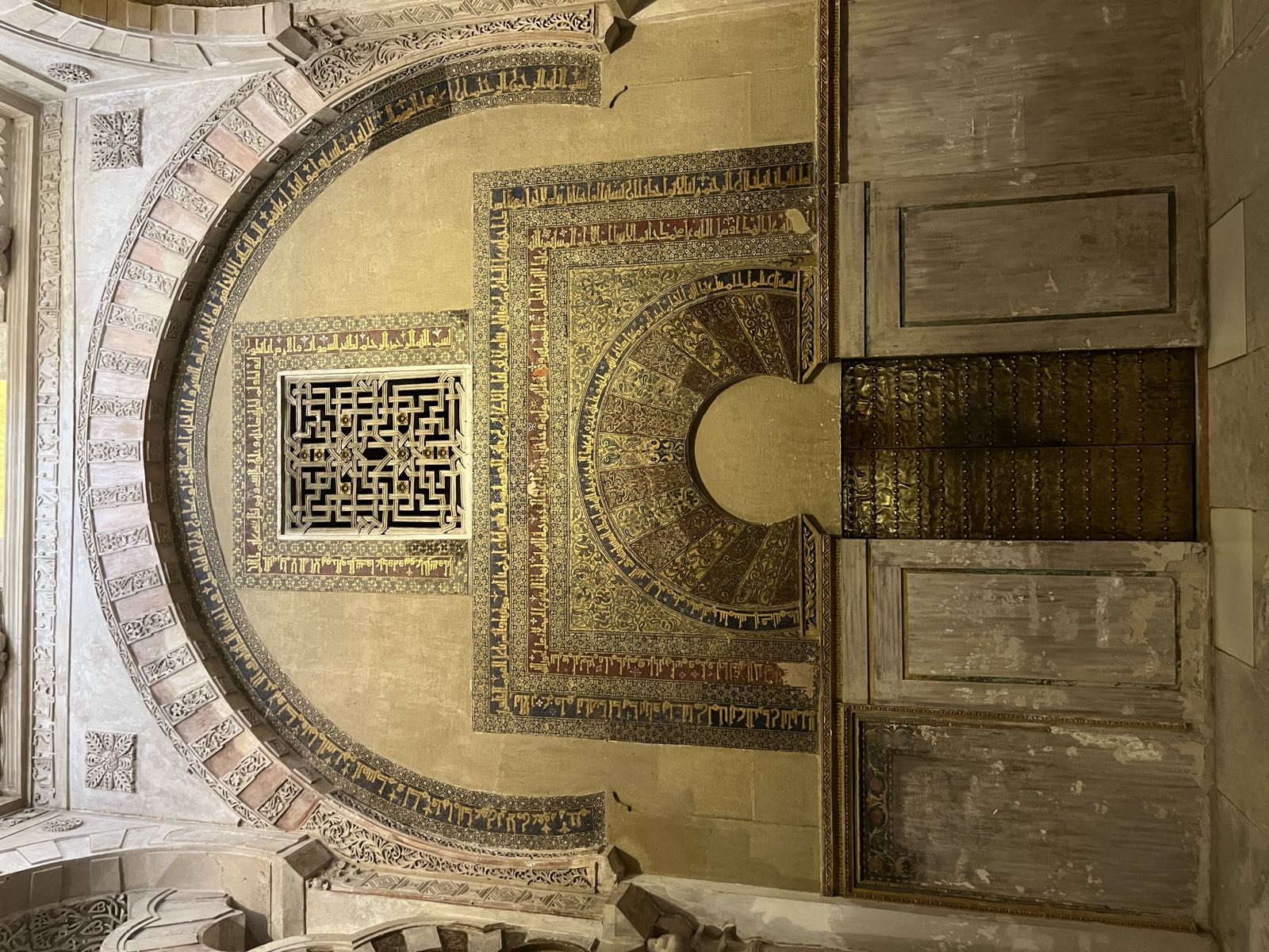 A wall near the mihrab featuring a bunch of Arabic-language text.