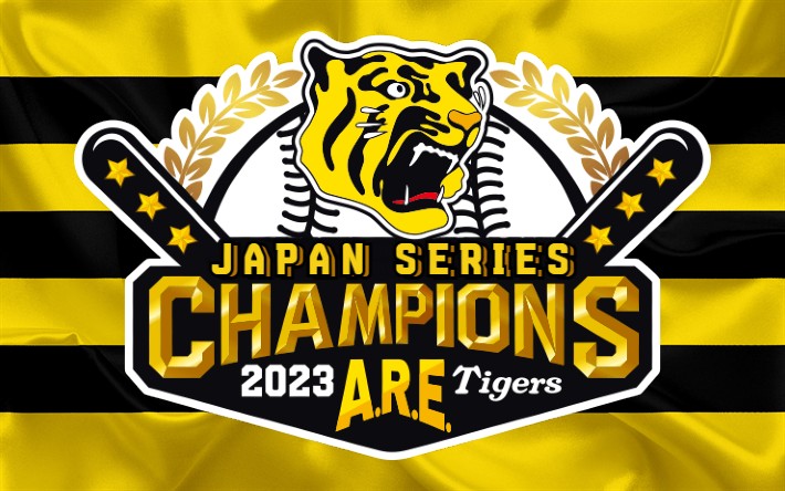 A yellow and black striped flag. In the center of the flag is the head of a tiger (the logo of the Hanshin Tigers) on top of a baseball. Below this are the words ’Japan Series Champions’.