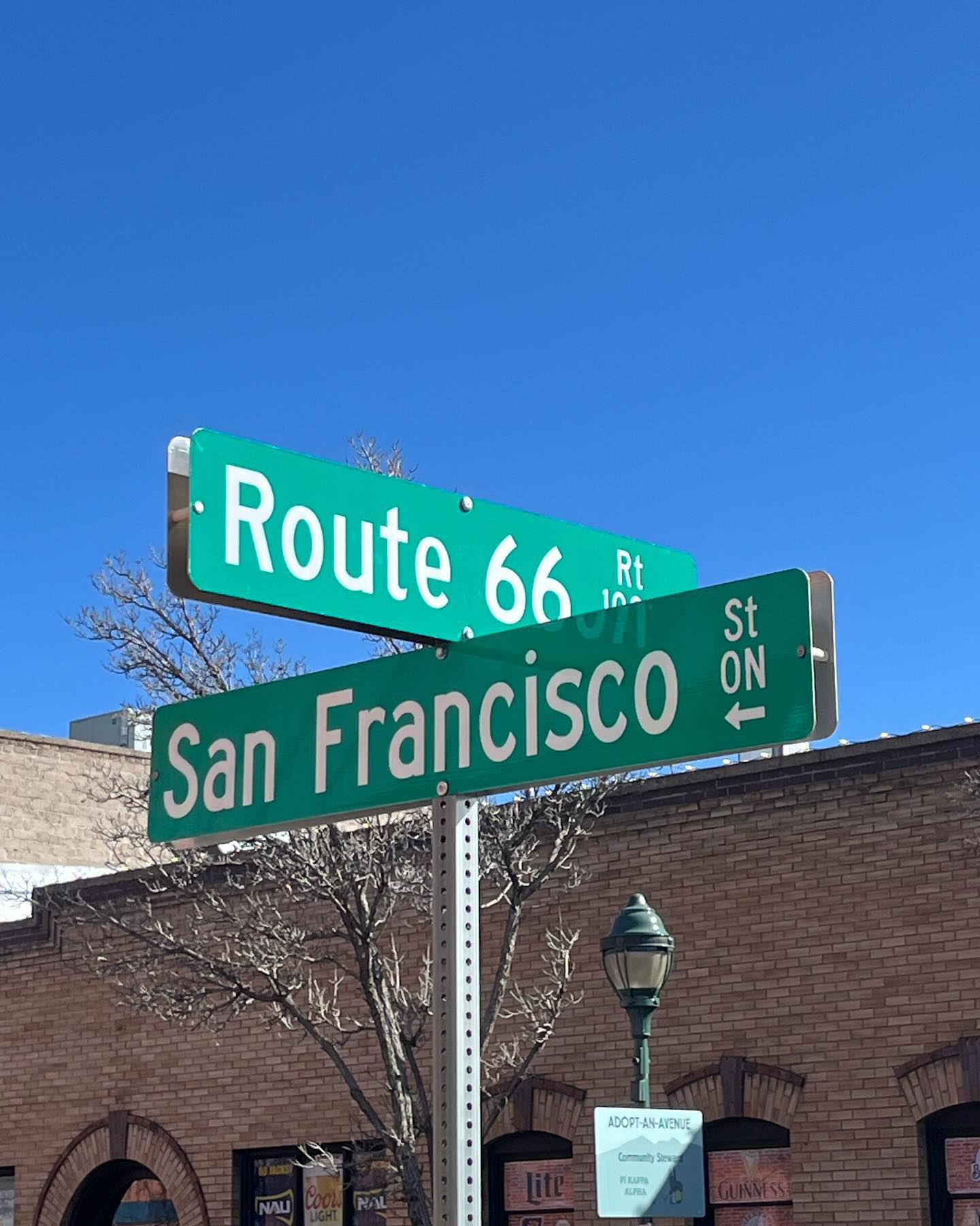 Two street signs at an intersection. One of the roads is San Francisco St., and the other is historic Route 66.