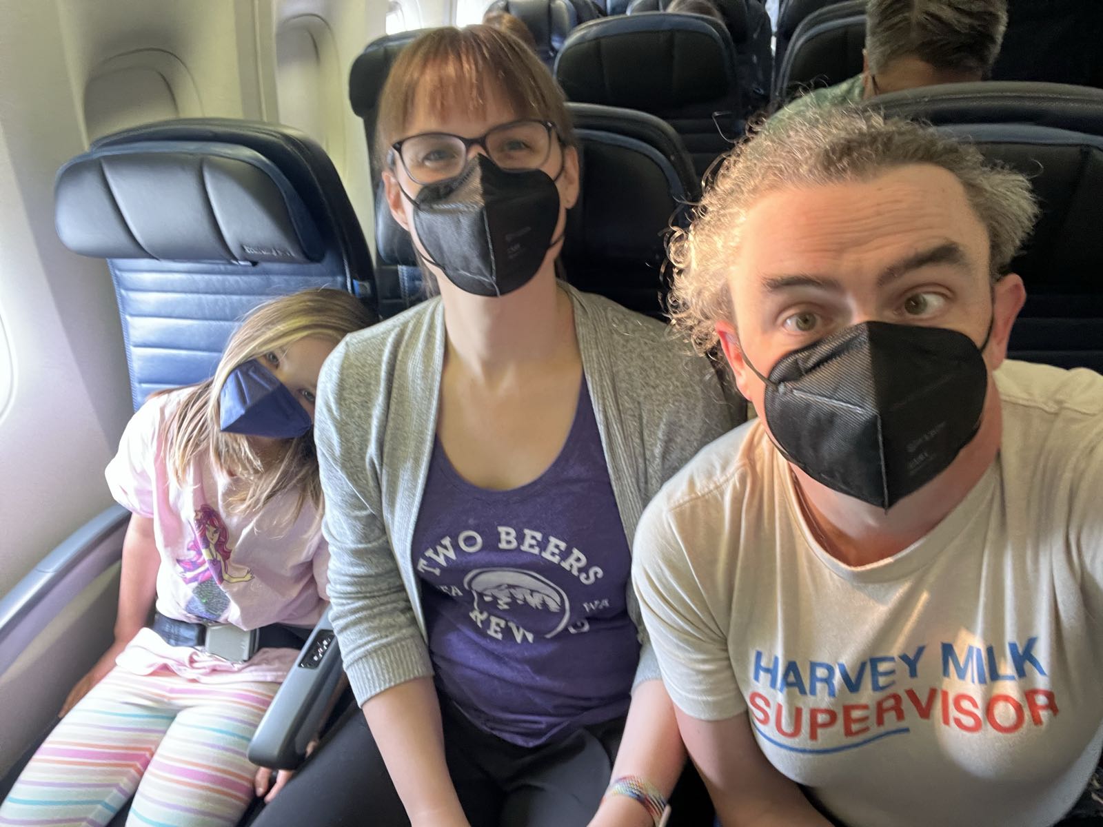 Three masked people sit on a plane.
EJ has the window seat. Eryn graciously took the middle, and I’m on the aisle.
