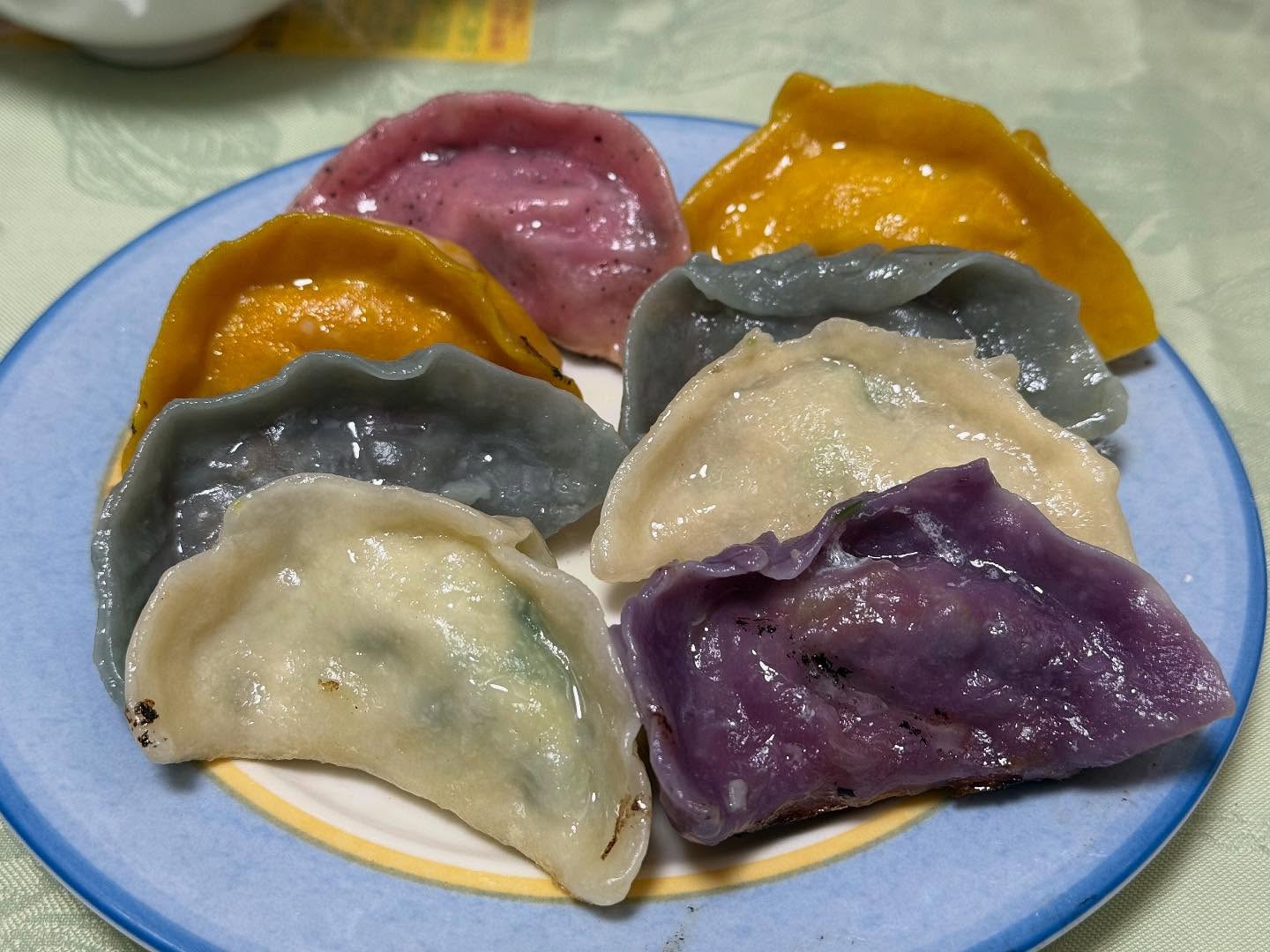 Many colorful dumplings are arrayed on a plate.