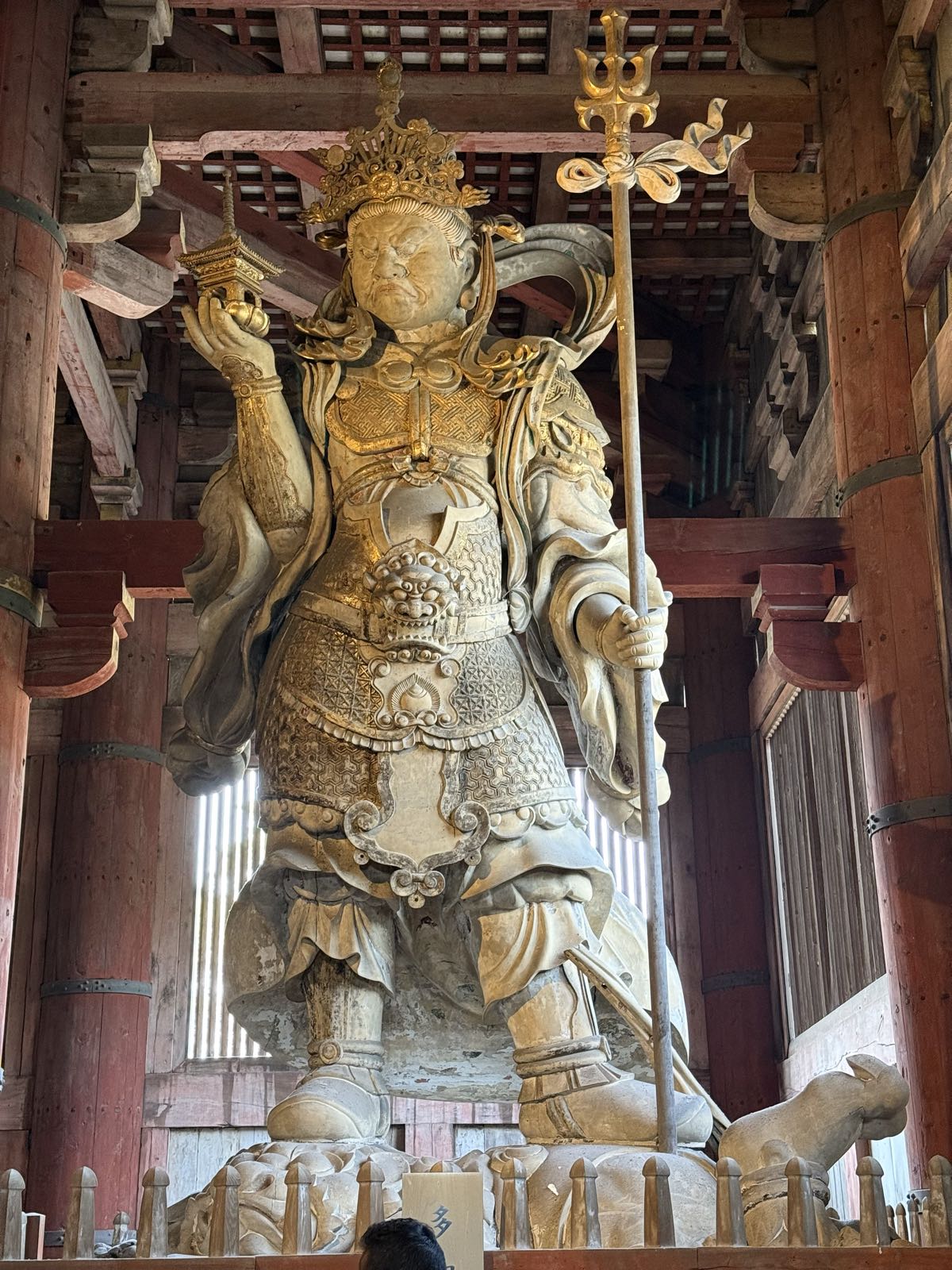 A large stone statue of a Buddhist guardian figure.