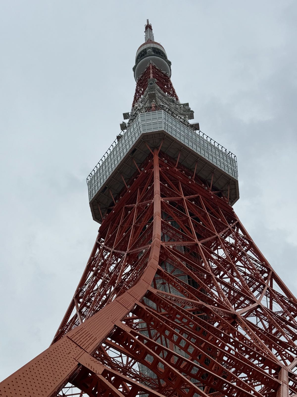 A large, orange and white tower sticks majestically into a gray sky.