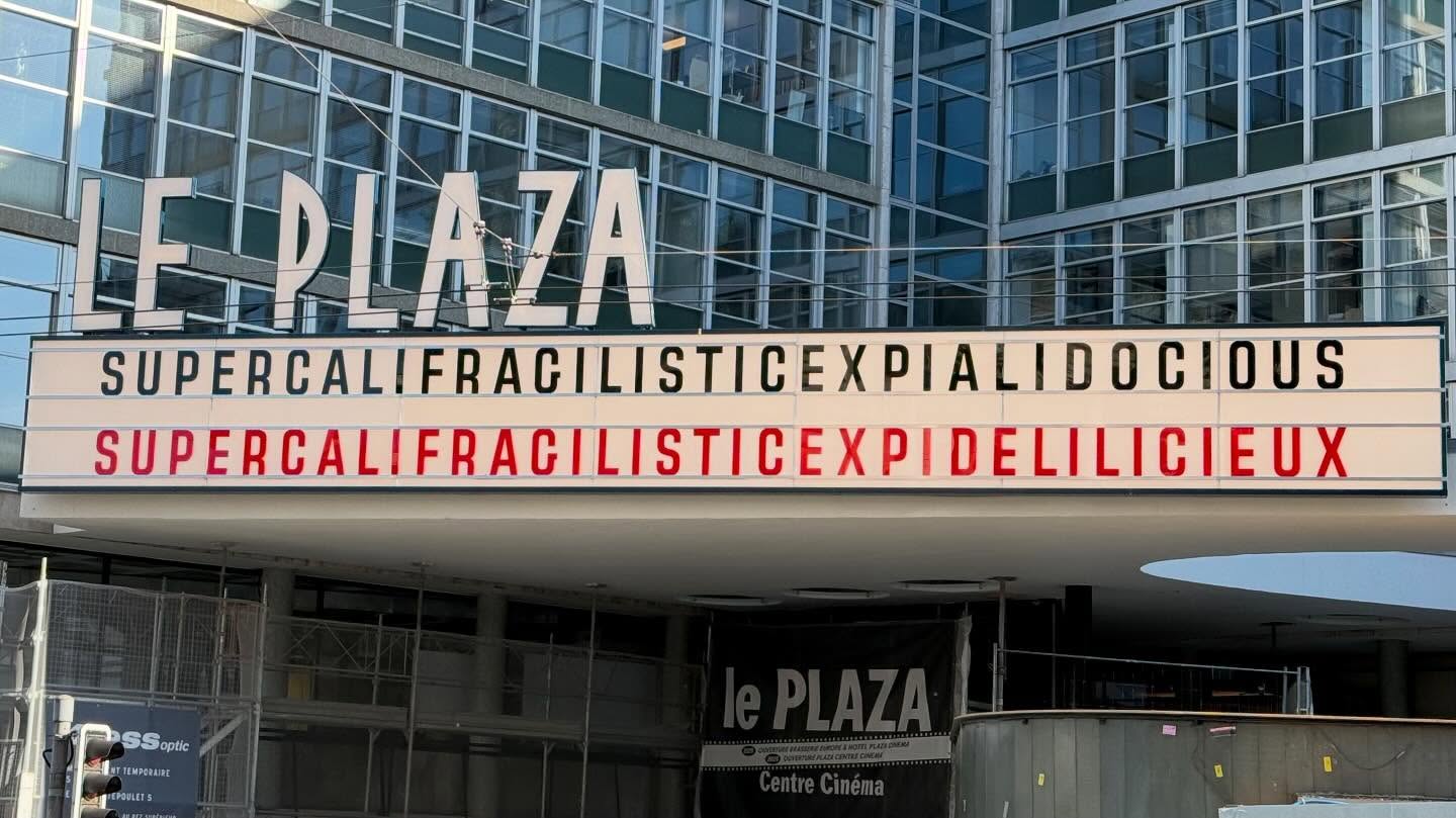 A building named Le Plaza has a large sign on its outside, which reads “supercalifragilisticexpialidocious supercalifracilisticexpidelilicieux.”