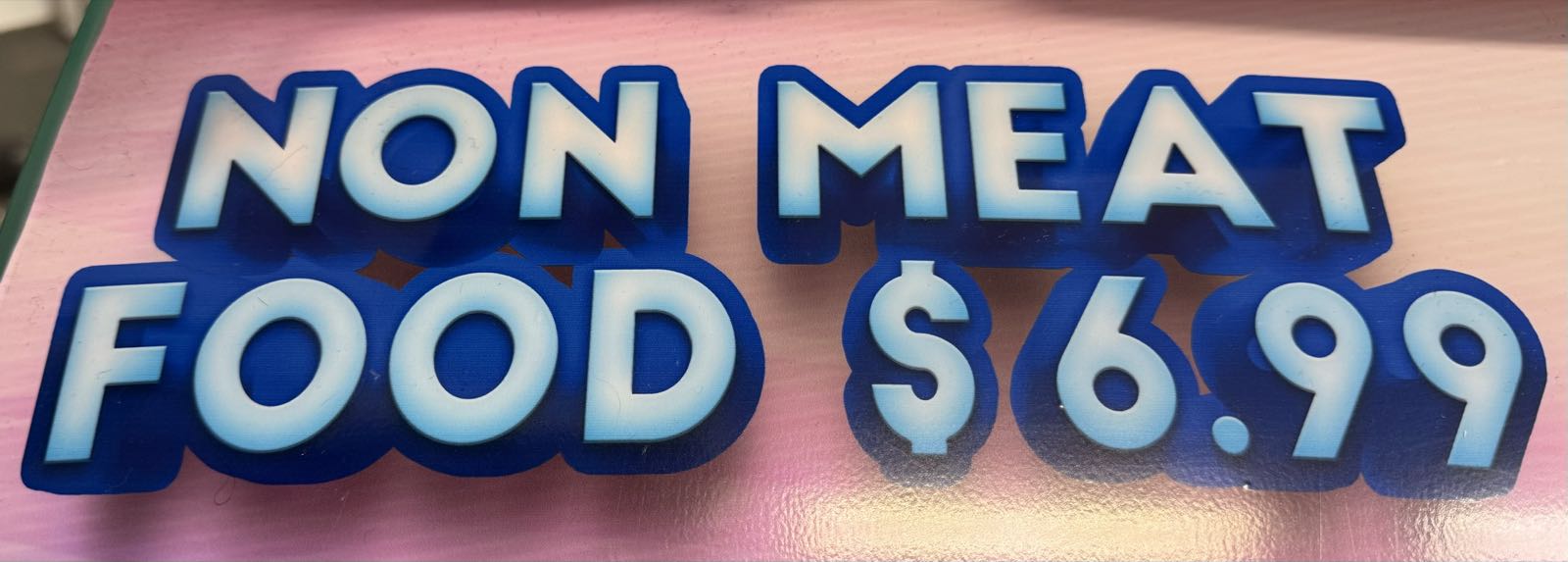 Blue and white letters read “NON MEAT FOOD $6.99” on a pink background.