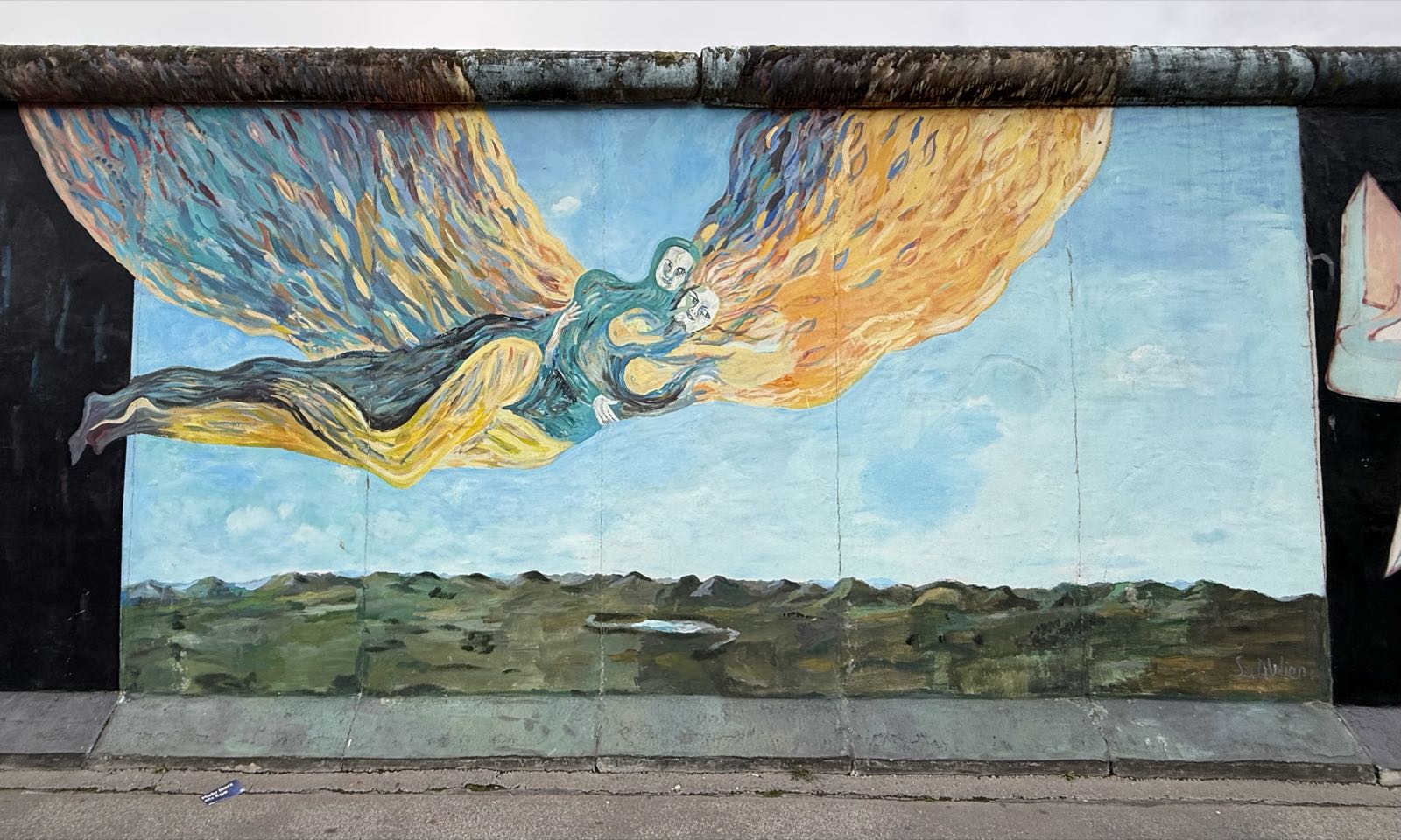 Two angels fly over a barren landscape.