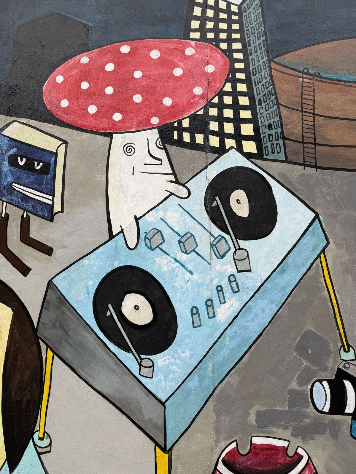 A mushroom with eyes and arms is spinning records on a DJ dual turntable.