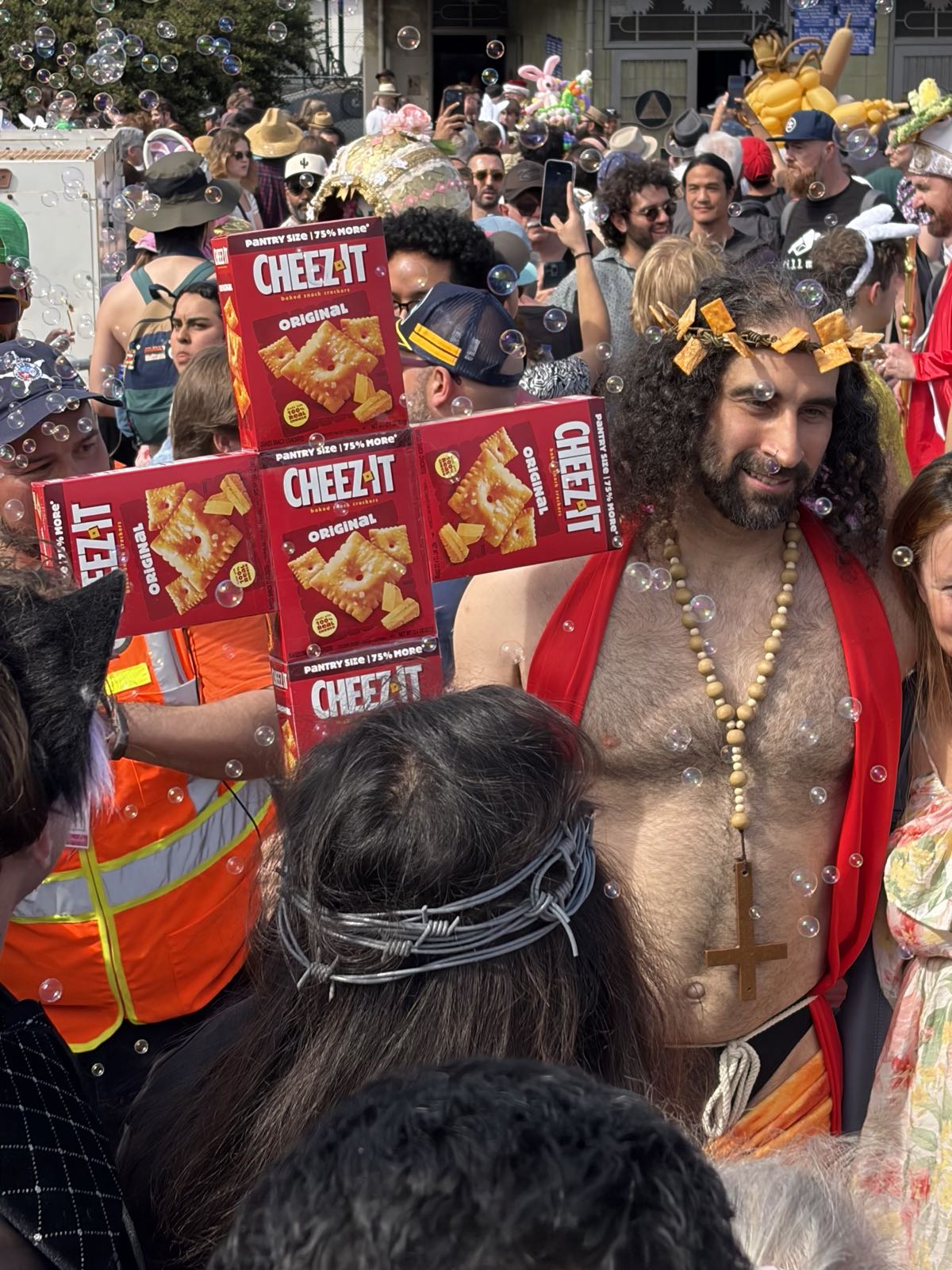 A man dressed as Jesus holds a cross made of Cheez-Its boxes.