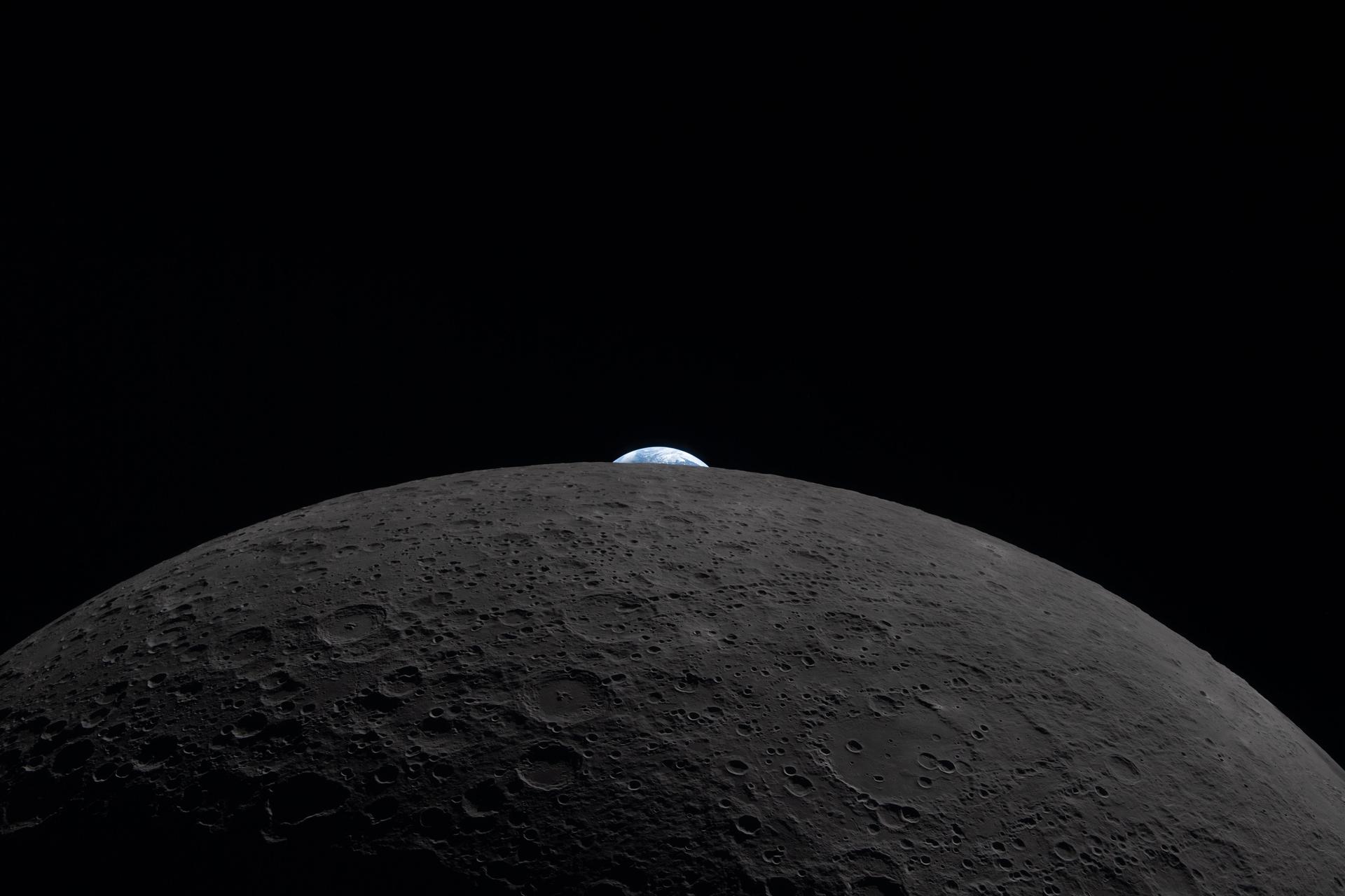 The Earth is peeking just above the lunar horizon.