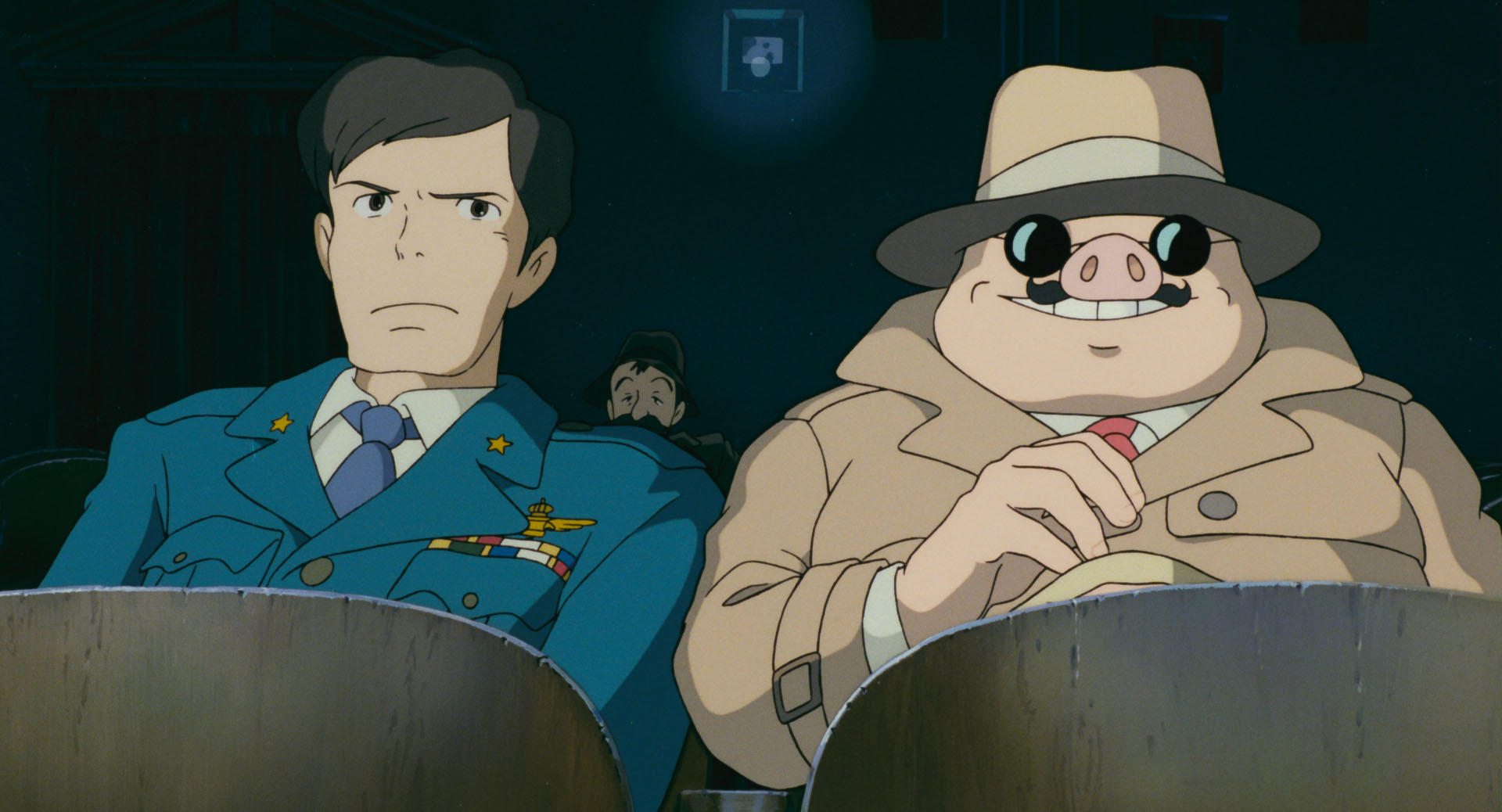 A man and a pig sit next to each other in a movie theater. The man is in the blue uniform of the Aeronautica Militare. The pig is in a beige trenchcoat with a matching hat. The military man is looking askance at the pig. The pig is wearing glasses, and his is an amused expression.