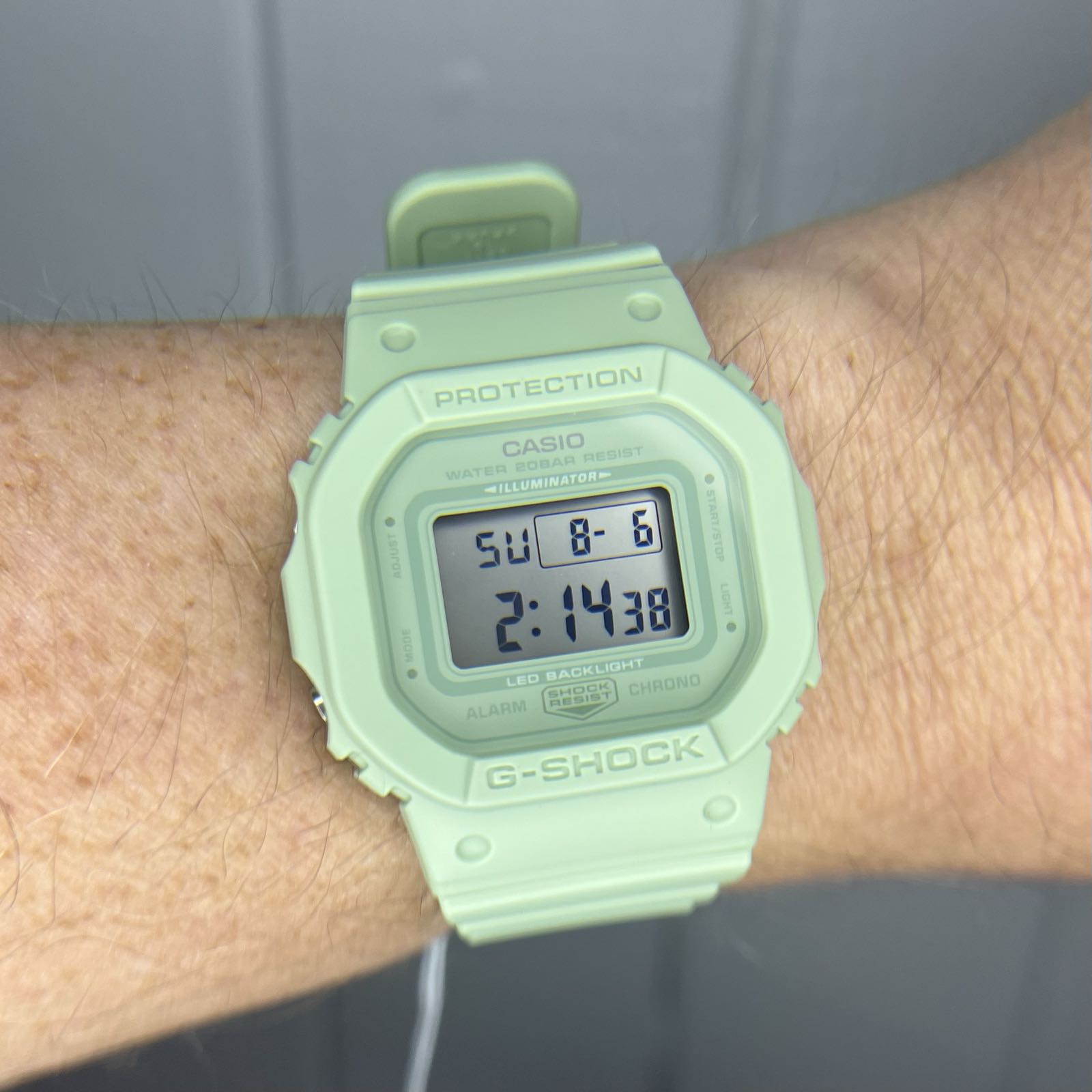A mint green plastic digital watch with a positive display.