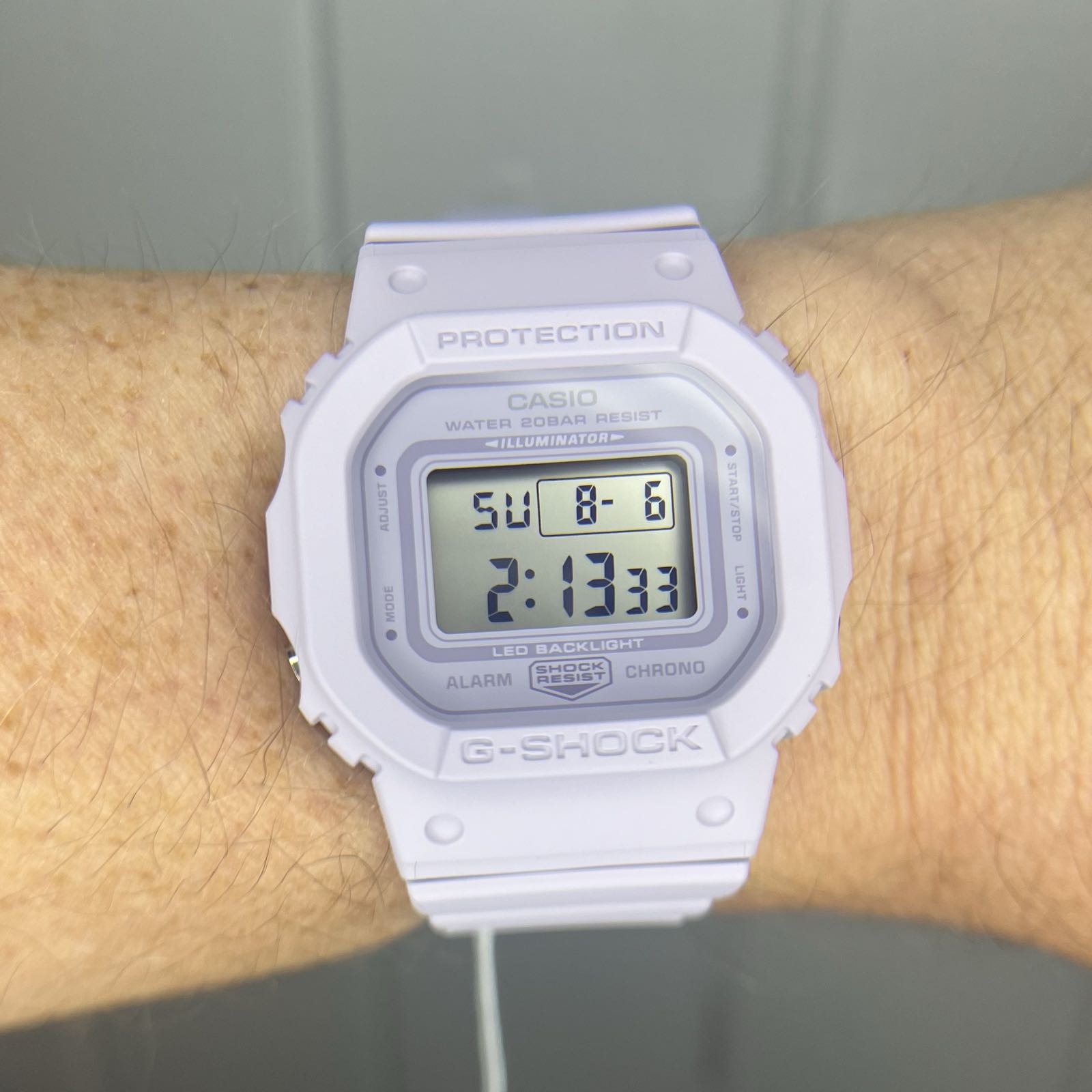 A lavender plastic digital watch with a positive display.