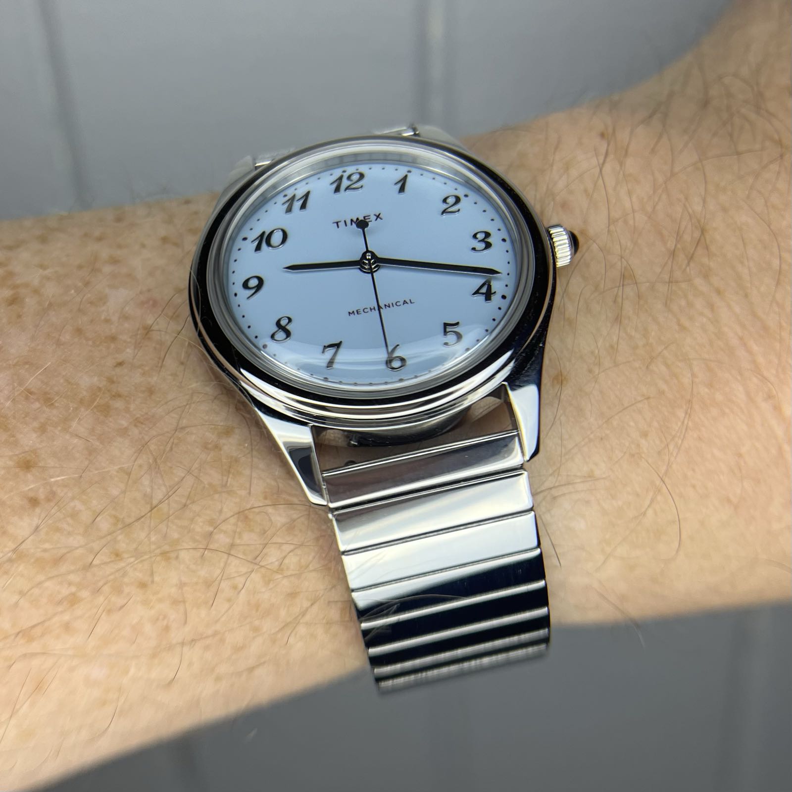 A steel dress watch on a steel bracelet. The face is baby blue, with steel Breguet numerals as hour markers.